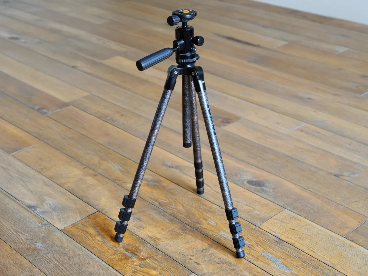 Leichtes Carbon-Stativ mit Kugelkopf auf einem hellen Holzboden im Tageslicht